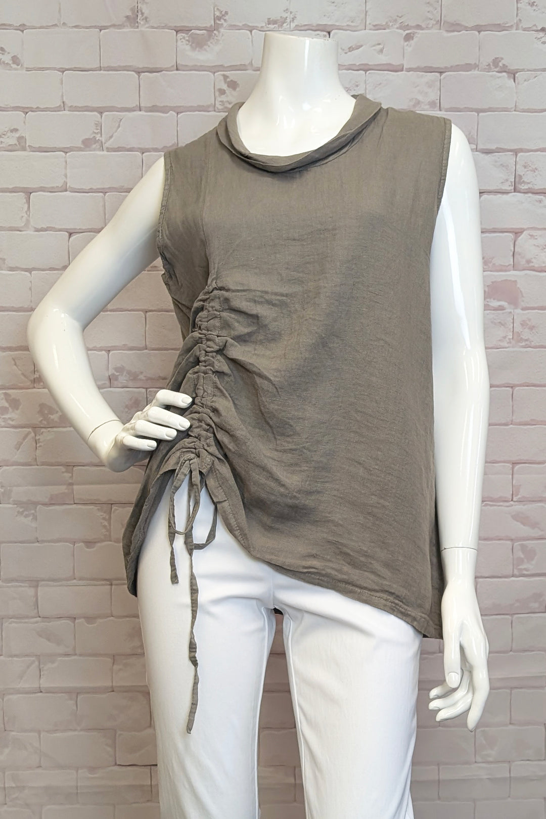 ETERN Spring 2025 Expertly designed, the Taupe Sleeveless Cowl with Drawstring combines a light drape cowl neck with a side hem tie drawstring featuring braided details.