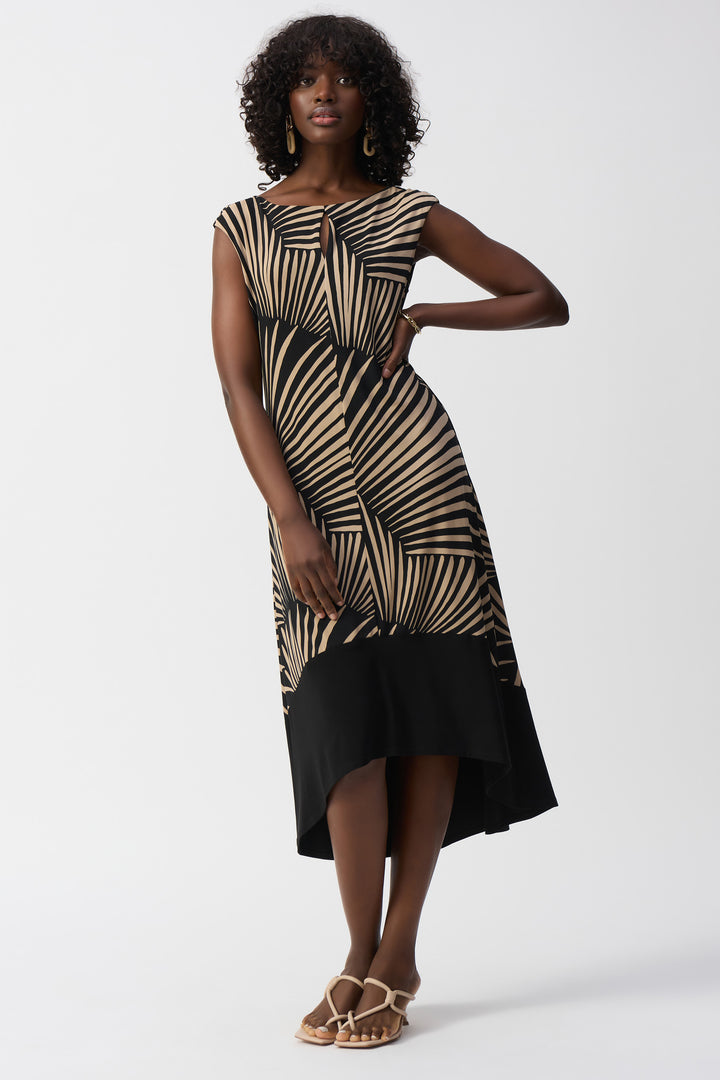 Joseph Ribkoff Spring 2025  This classic palm print, silky smooth dress features a boatneck with a keyhole design and a hi lo contrast hemline, making it perfect for both the office and vacation. 