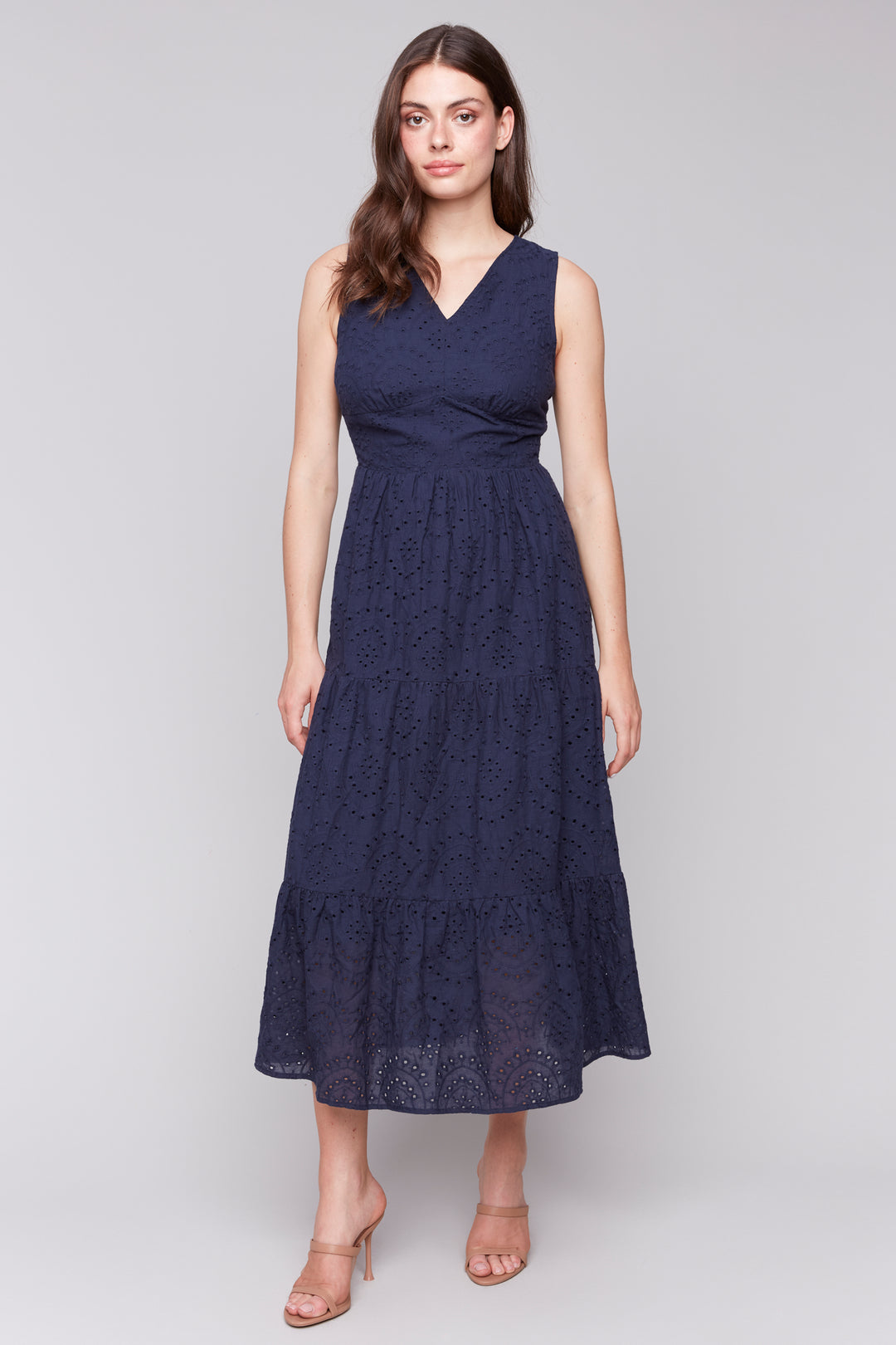 Charlie B Spring 2025  This all-cotton dress features a v-neck and an eyelet design all-over, giving it a sweet and feminine touch. With an elastic back waist, it's both comfortable and flattering for any spring or summer occasion. 