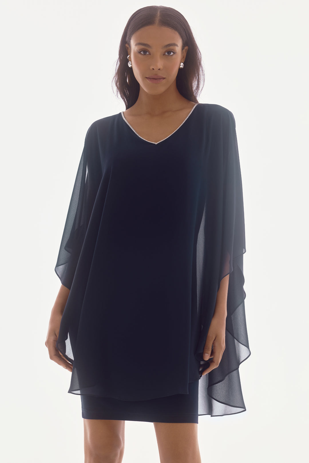 Joseph Ribkoff Spring 2025  Crafted from silky knit fabric, this knee length dress features a jewel v-neckline and flare short sleeves. And the chiffon drape? 