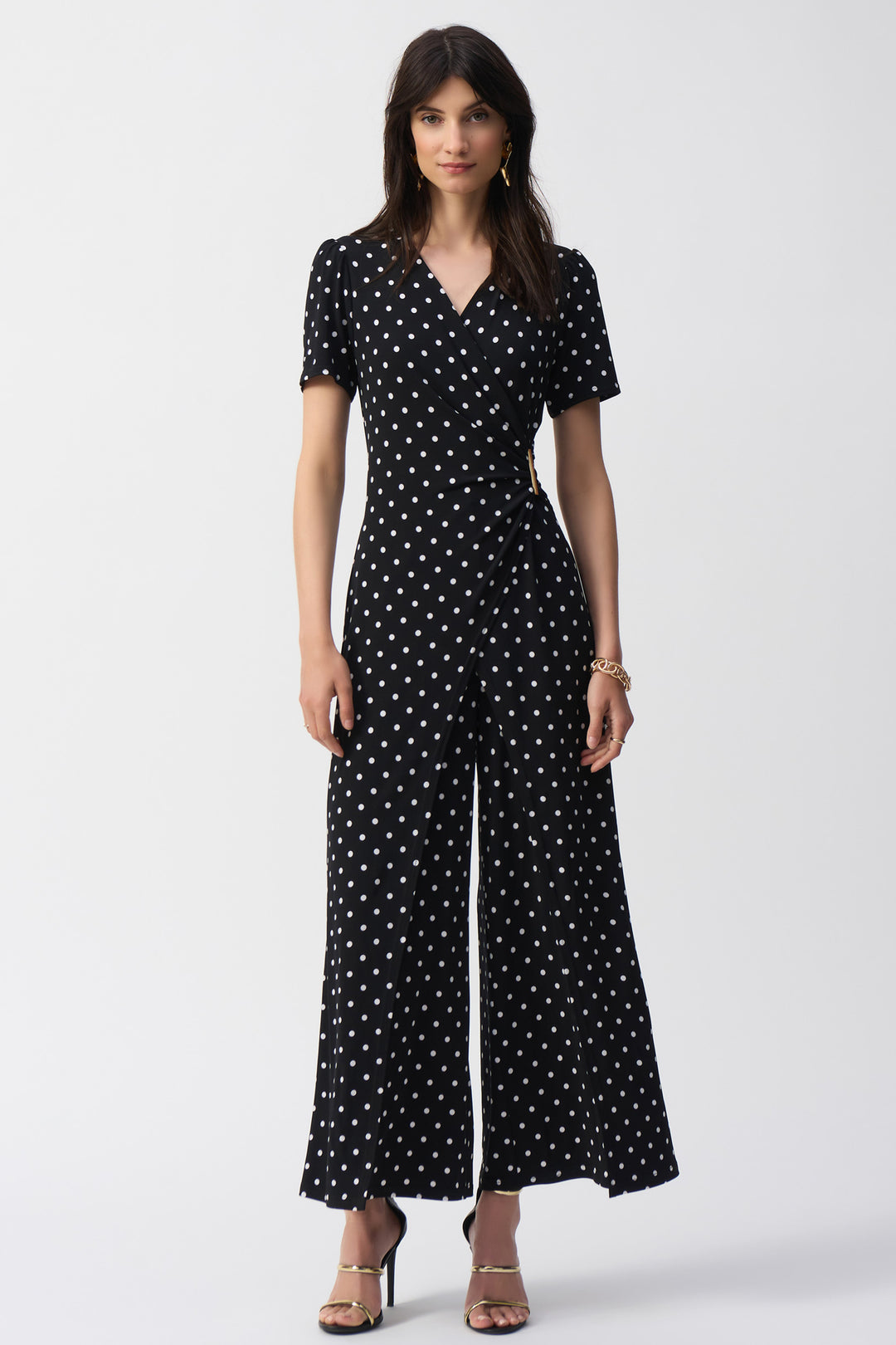 Joseph Ribkoff Spring 2025 The wrap and drape style jumpsuit exudes effortless style while the v-neck and buckle detail add a touch of sophistication.