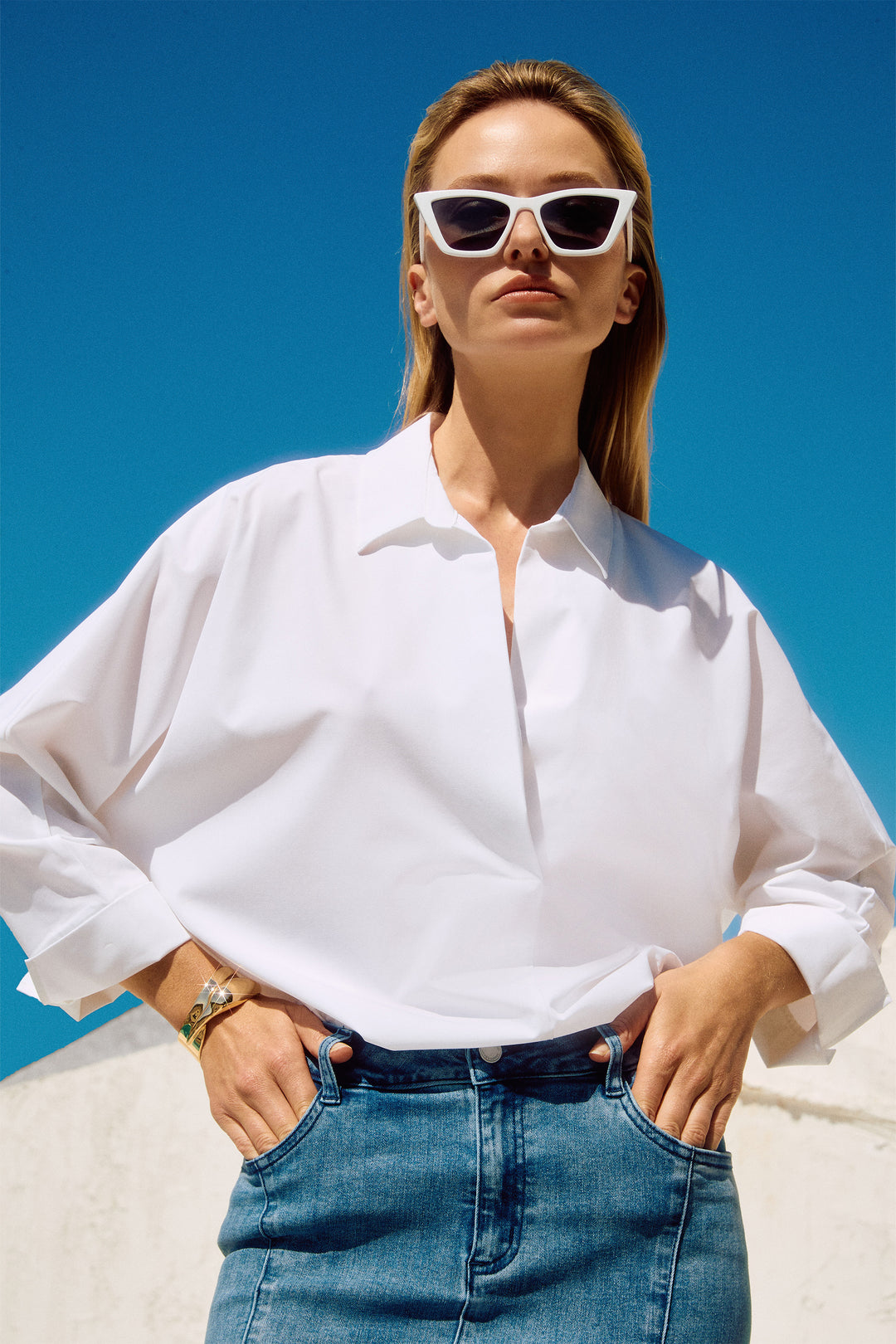 Joseph Ribkoff Spring 2025  This top features a unique overlapping v-neck with a classic collar, giving it a boxy fit that is both comfortable and flattering. 