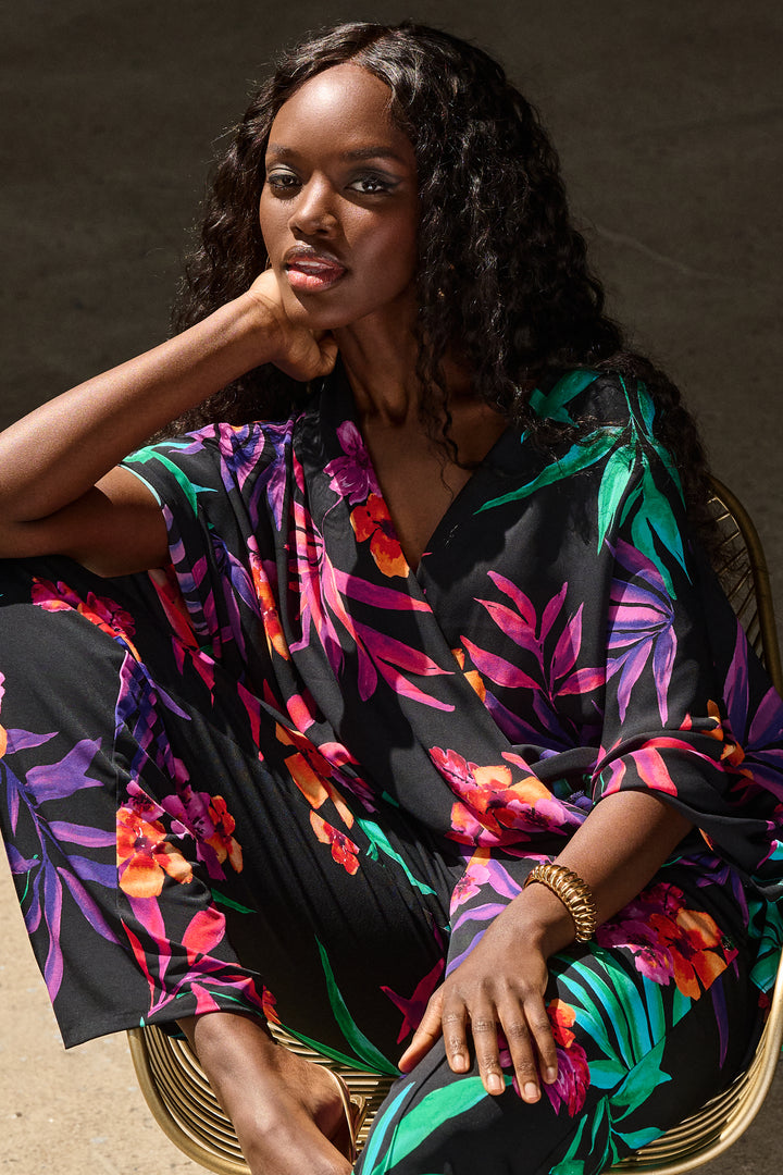 Joseph Ribkoff Spring 2025 Featuring a wrap front design and looser dolman sleeves that provide a loose, airy fit for a delightful look and feel, this wonderful vibrant blouse will become a go-to item in your summer and vacation wardrobe!