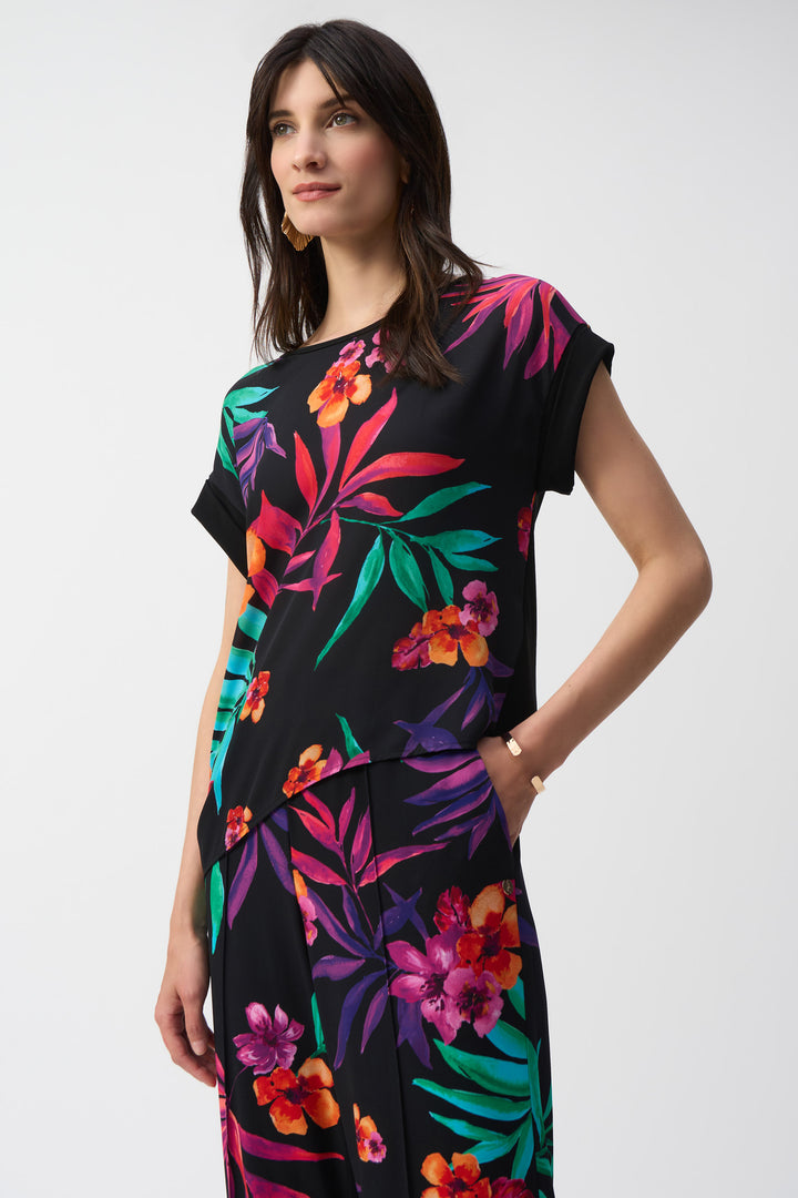Joseph Ribkoff Spring 2025 Its bold floral print and light, airy fabric will transport you to paradise! The crew neck and short cap sleeves add a casual touch, while the tie knot detail at the waist flatters your figure.