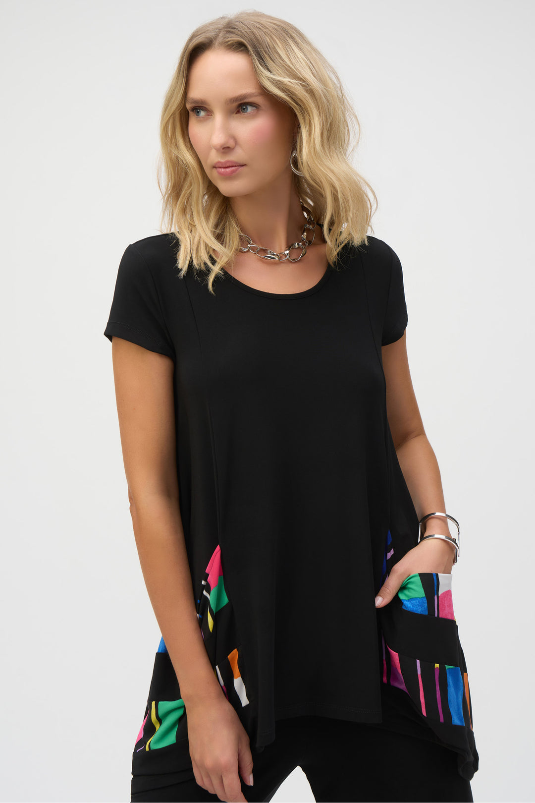 Joseph Ribkoff Spring 2025 Expertly crafted from silky knit, this tunic features a scoop neckline and banded hem and sleeves for a stylish and versatile look. Its longer-than-average length offers both comfort and fashion. Dress it up or down with ease this season!