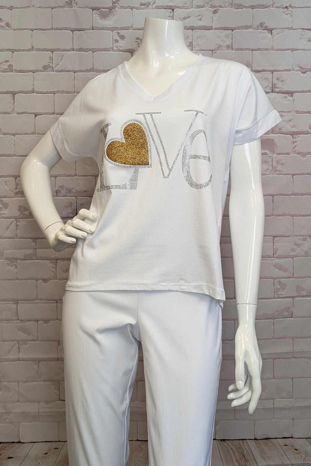 AMBRA Spring 2025 Made with lightweight and durable cotton fabric, this classic fit t-shirt features a neat gold glitter LOVE &complete with heart! Perfect for a light and casual look with a touch of playfulness.
