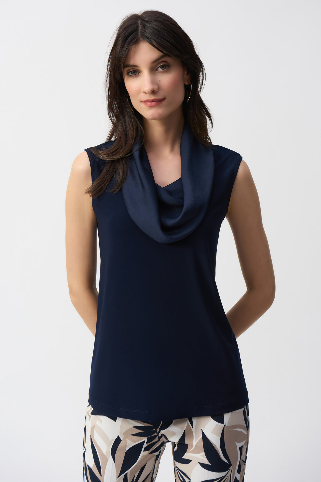 Joseph Ribkoff Spring 2025 Featuring a drape neckline and sleeveless silhouette, it's made from luxe satin fabric and is crafted in Canada. Pair them with any dress pants for the ultimate 'killer look' this summer!