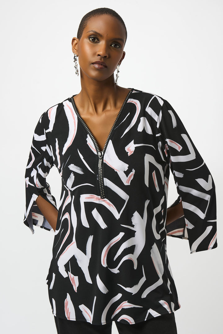 Joseph Ribkoff Fall 2025 This tunic features a sophisticated V-neckline with a discreet zipper, complemented by 3/4 length flare sleeves that add a graceful touch. Its flowy silhouette and neat abstract print create a modern yet timeless look, perfect for year-round wear.