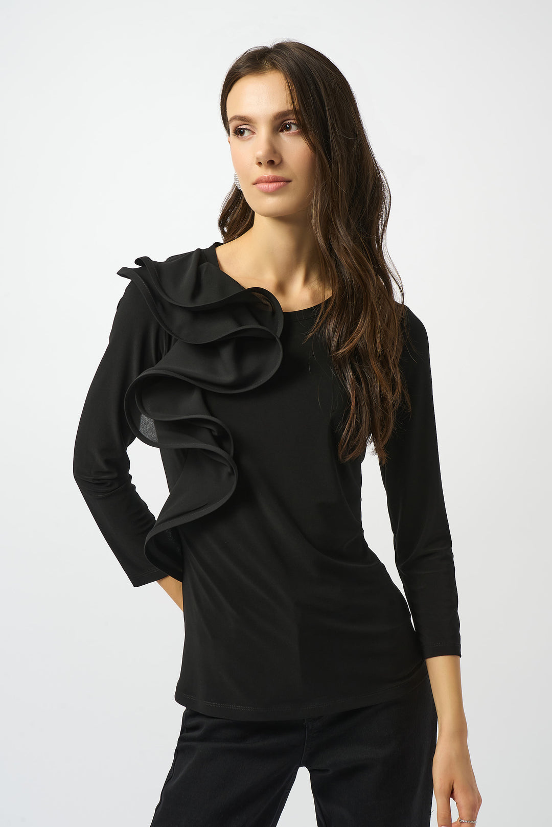 Joseph Ribkoff Fall 2025 
Elevate your wardrobe with this black pullover top, featuring a refined ruffle detail on one fitted shoulder. Crafted from silky knit fabric, it offers a smooth, elegant feel. 
