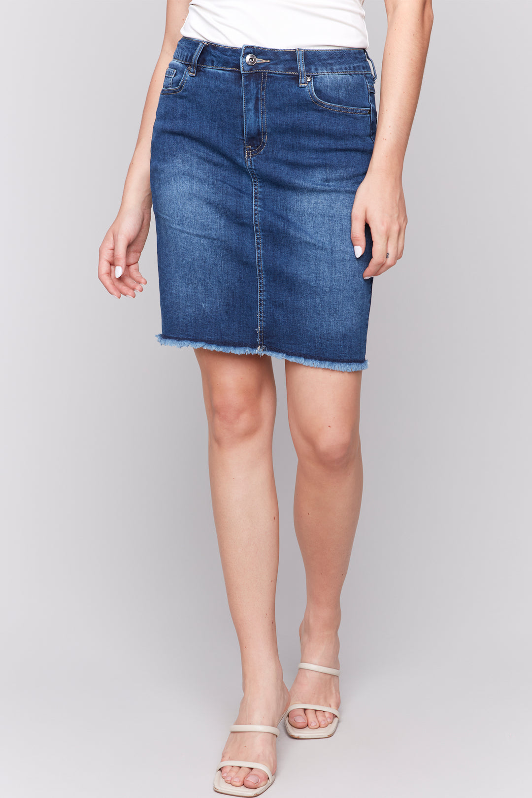 Charlie B Spring 2025 Made with 5 pockets and a classic denim design, this skirt will elevate any outfit. Its standard rise and signature frayed hem add a touch of luxury, making it the star of the show!