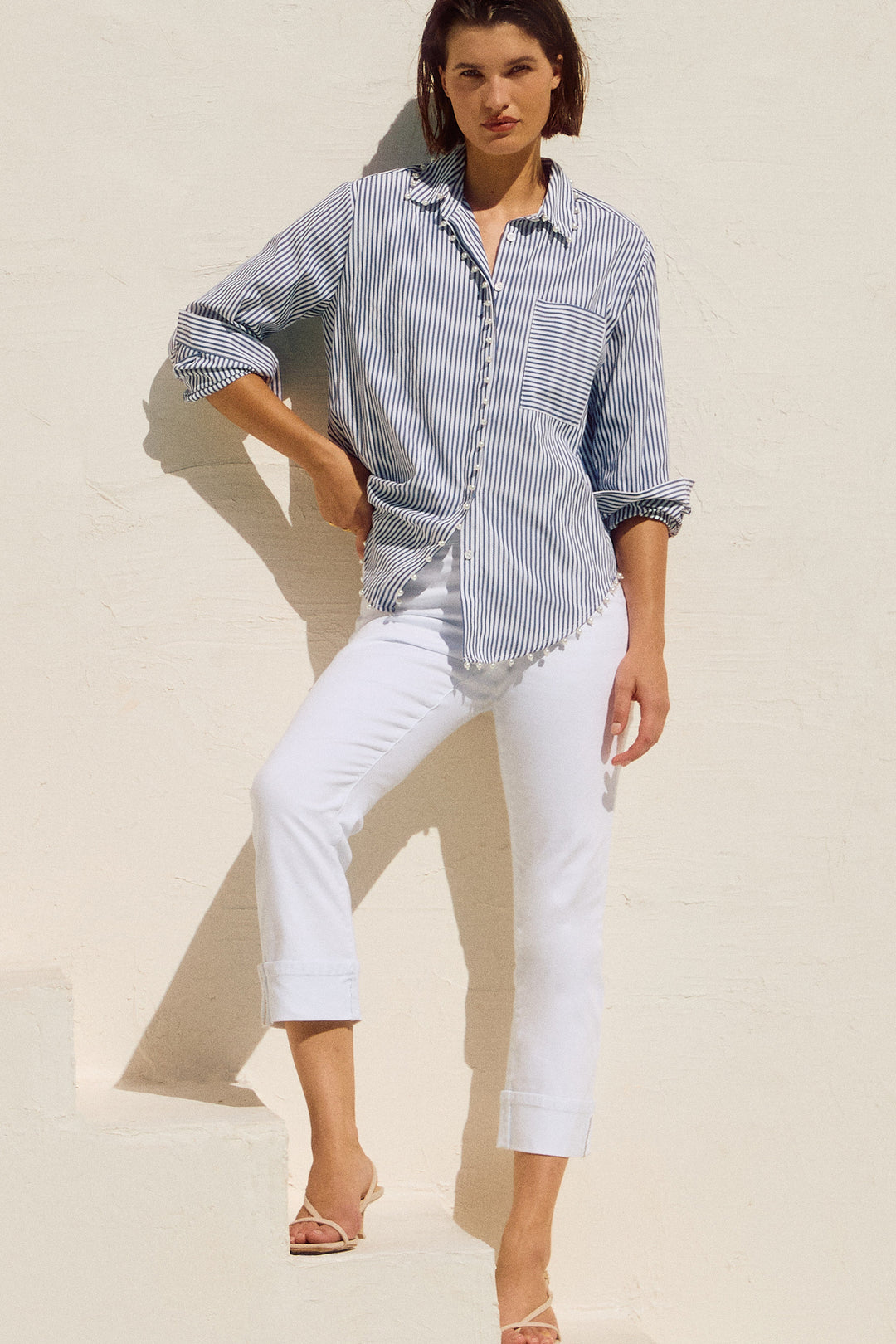 Joseph Ribkoff Spring 2025  Made with a soft cotton blend and featuring a classic zipper and fly waistband, these jeans also offer a good stretch for a flattering fit. But the real star of the show? The rolled cuffs with just the right amount of bling! 