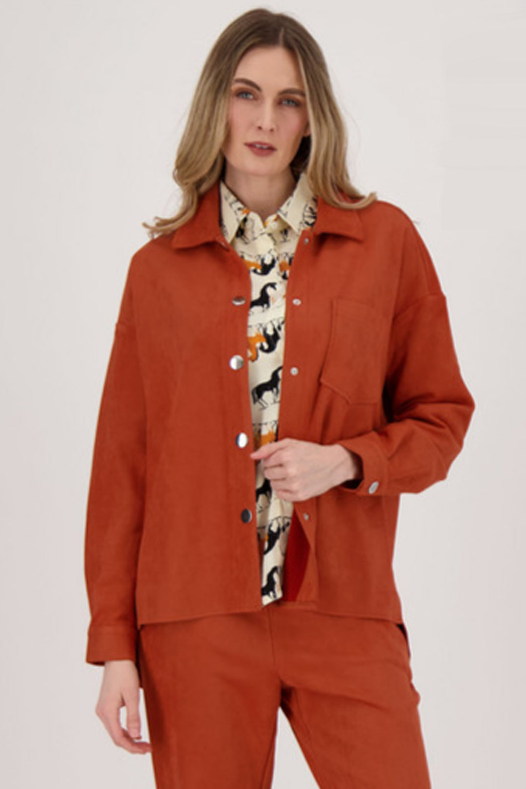 Spanner Fall 2024 Made with faux suede fabric, it's perfect for layering and has all the classic blouse elements. Keep it open for a more casual look, or style it for a more elevated outfit.