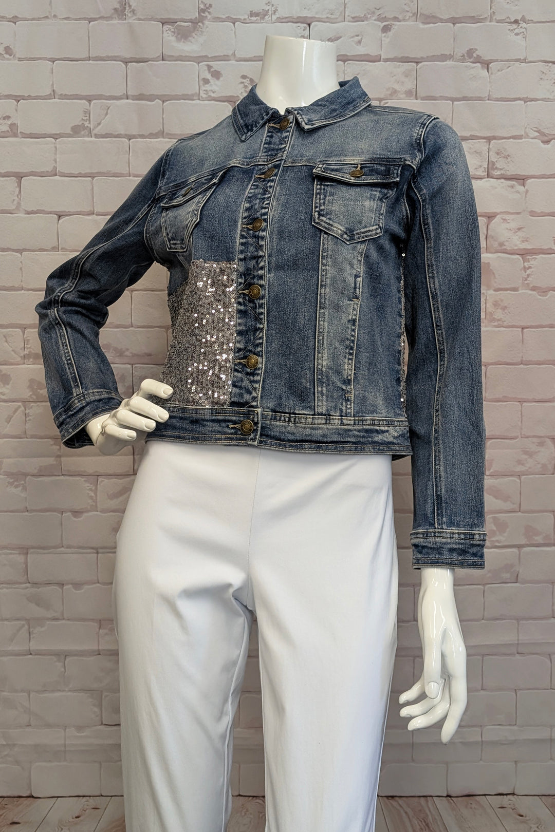 ANGELA MARA Spring 2025 This sequin front jean jacket combines classic denim elements with a modern, trim fit for a sleek silhouette. Designed for the fashion-forward individual, it features a striking cool sequin patch that elevates the timeless style.