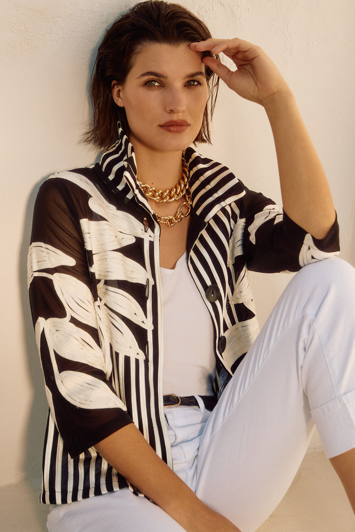 Joseph Ribkoff Spring 2025  This fancy piece features a bold leaf pattern and a high neck collar for a resort feel! The mesh and satin combination make it versatile, wear it as a top or jacket. 