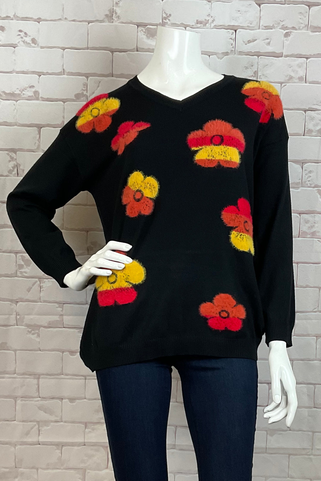 Ness Fall 2024 Made from light knit sweater material, this sweater top features a sot cut v-neck and a cute bright fuzzy flowers print on the front.