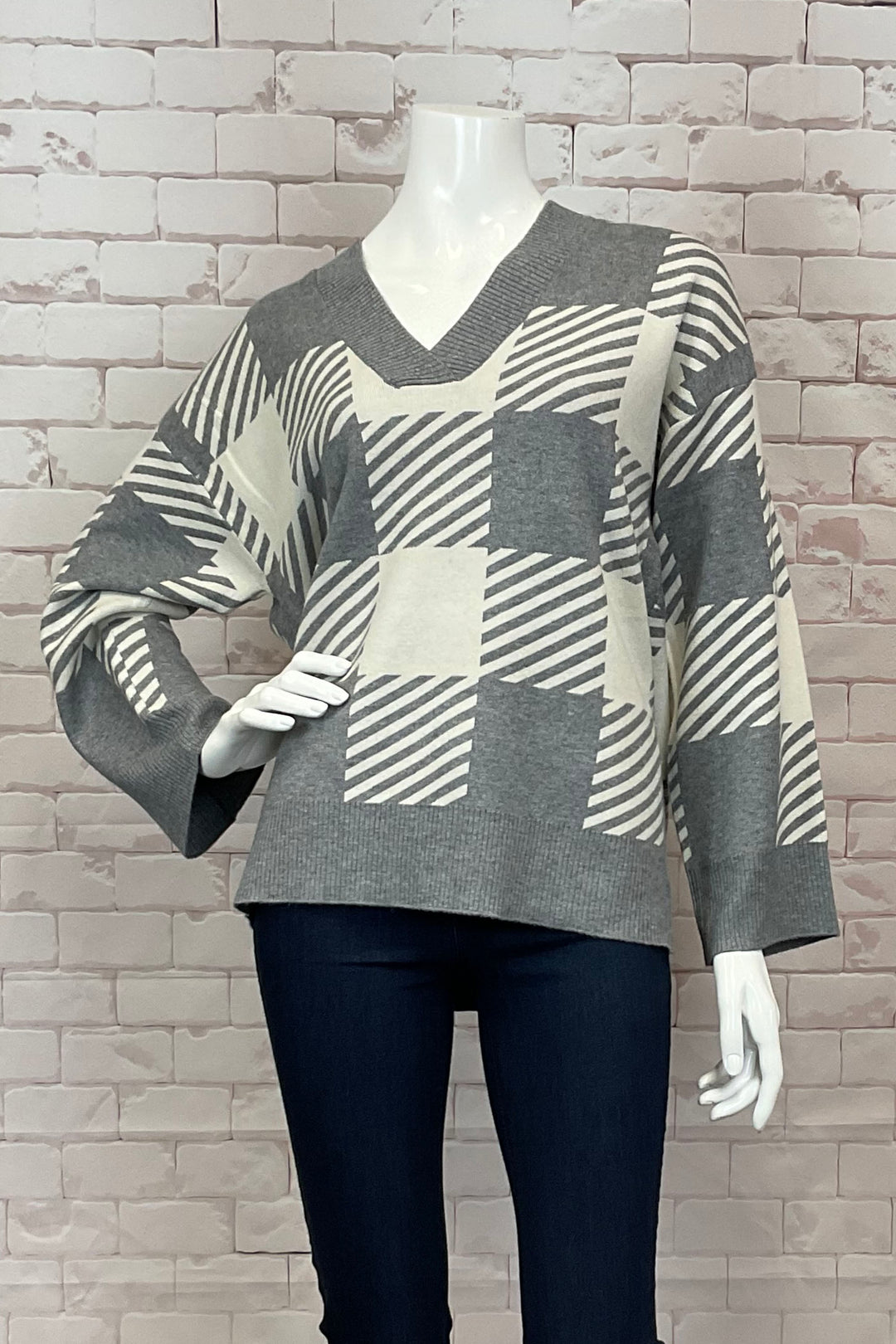 B. Young Fall 2024 Featuring a loose fit and full length sleeves, this pullover offers both style and comfort. The standout check print on the front and back, along with the contrast hem and cuffs, add a touch of uniqueness.