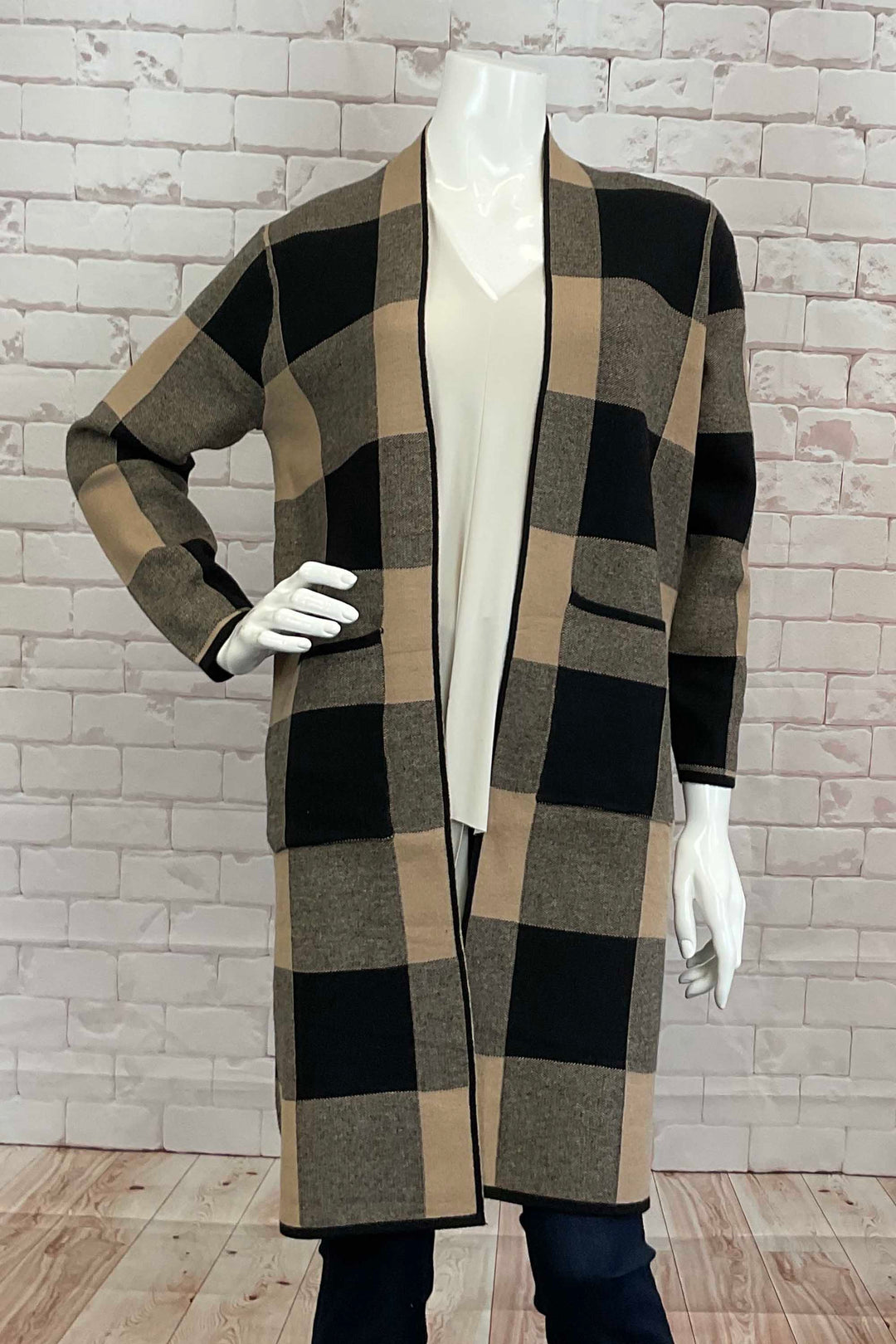 Variations Fall 2024 Adorned with an eye-catching plaid print, this knee-length, open-front style exudes elegance. Front pockets add functionality to this classy fall piece, perfect for staying warm and stylish.