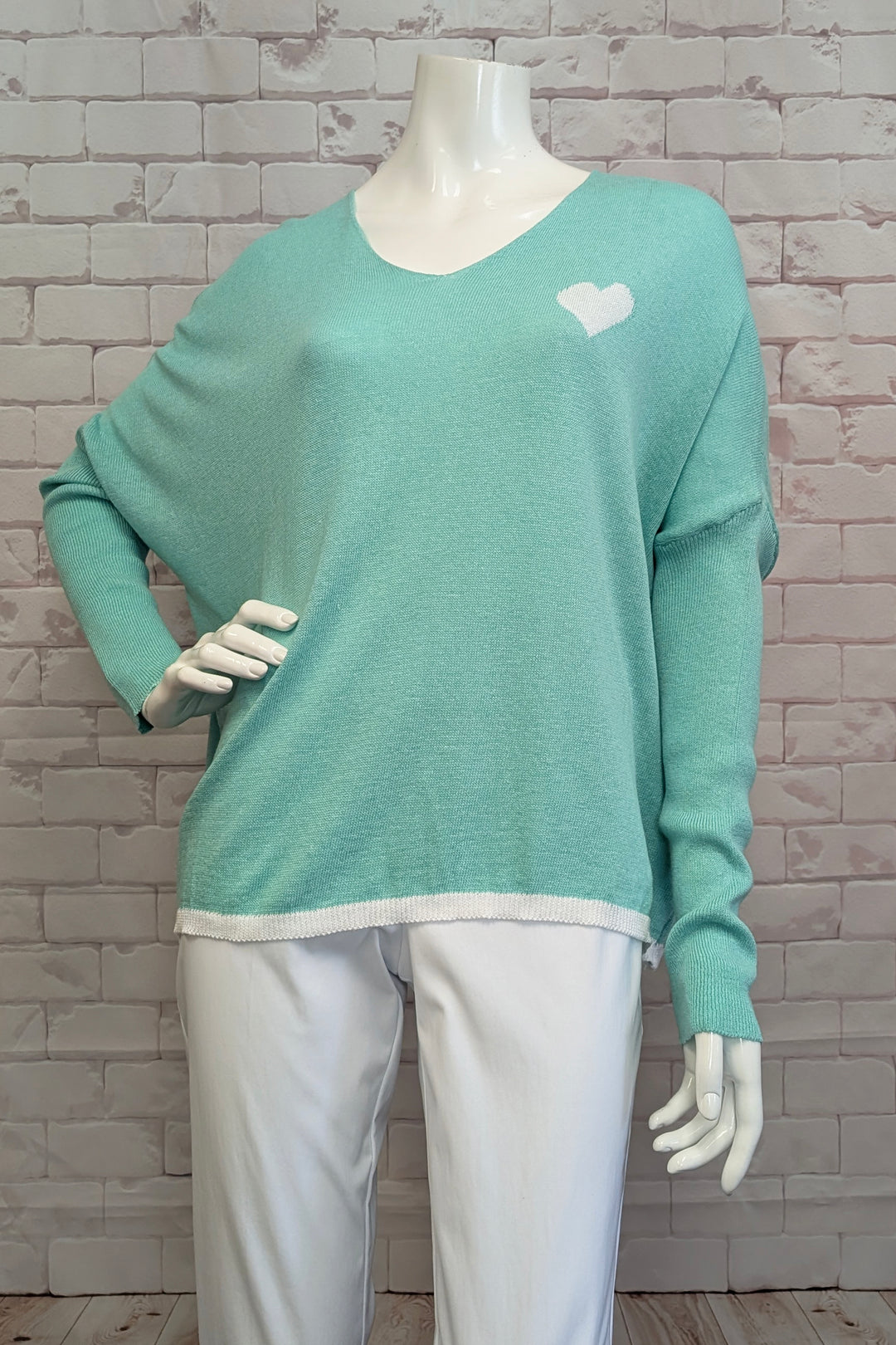 ANGELA MARA Spring 2025 This all-cotton pullover features a charming heart detail at the neckline and relaxed dropped shoulders for a casual, comfortable fit. Its versatile design allows for effortless layering, making it an ideal piece to wear year-round.