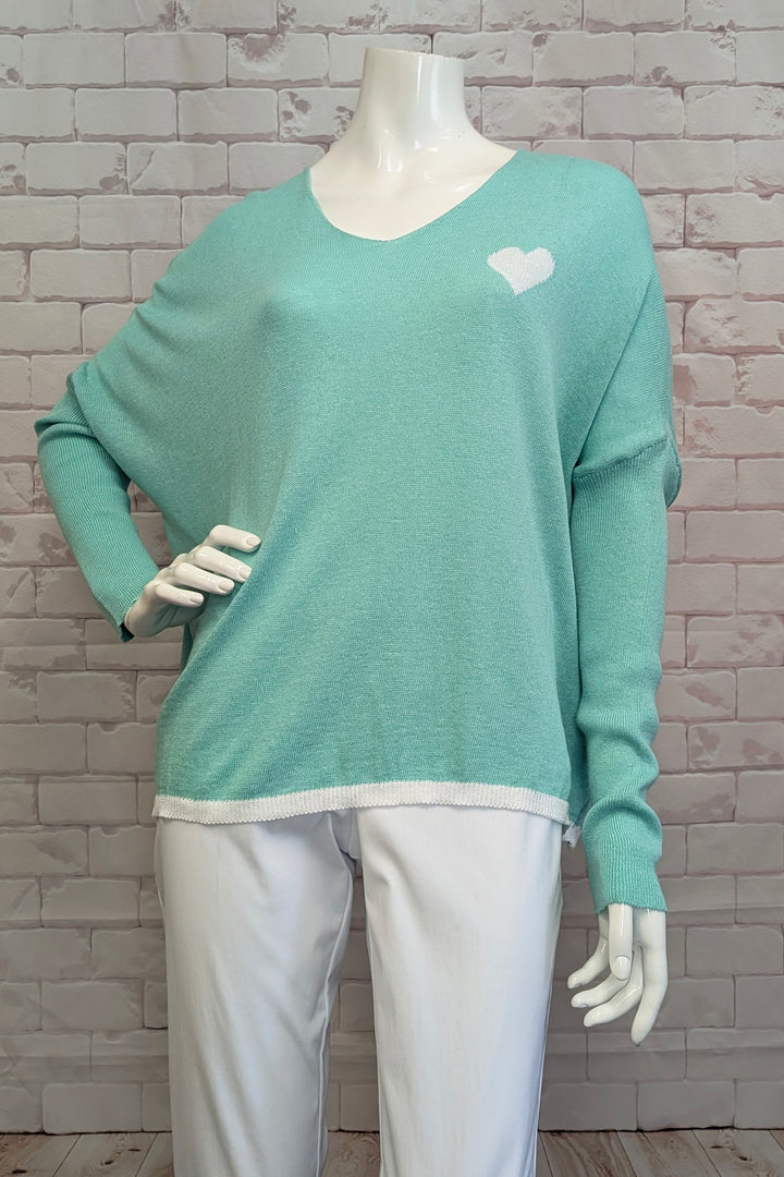 ANGELA MARA Spring 2025 This all-cotton pullover features a charming heart detail at the neckline and relaxed dropped shoulders for a casual, comfortable fit. Its versatile design allows for effortless layering, making it an ideal piece to wear year-round.