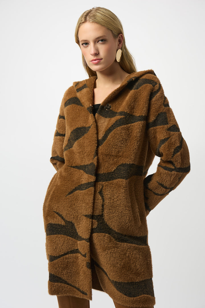 Joseph Ribkoff Fall 2025  Made with soft feather yarn and a warm faux fur hood, this sweater knit coat also features front buttons and convenient side pockets. 