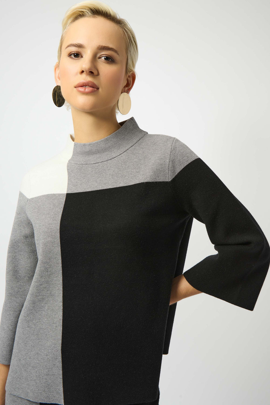 Joseph Ribkoff Fall 2025  Featuring a classic mock neck and soft, lightweight fine knit fabric, this sweater top offers a bold yet soft colour block design and an overall relaxed fit. 