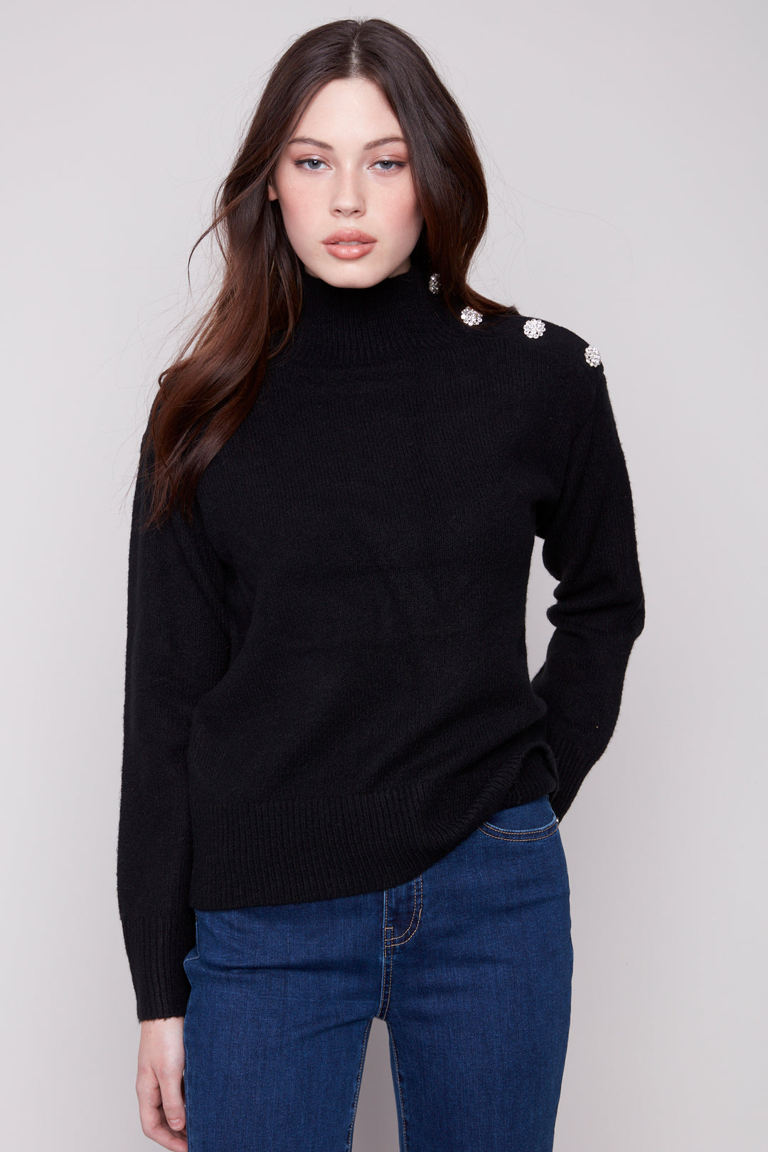 Charlie B Fall 2025 
Elevate your cozy wardrobe with this classic long-sleeve mock neck sweater featuring sparkling rhinestone shoulder buttons. 
