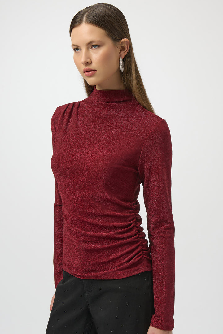 Joseph Ribkoff Fall 2025 
 The all-over glitter and side ruching add festive flair, making it perfect for pairing with dress pants or skirts at any seasonal gathering. 