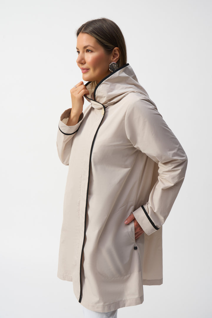 Joseph Ribkoff Spring 2025 Thoughtfully designed with front pockets and contrast trim lining along the neckline, opening, and cuffs, it offers subtle yet striking detail.