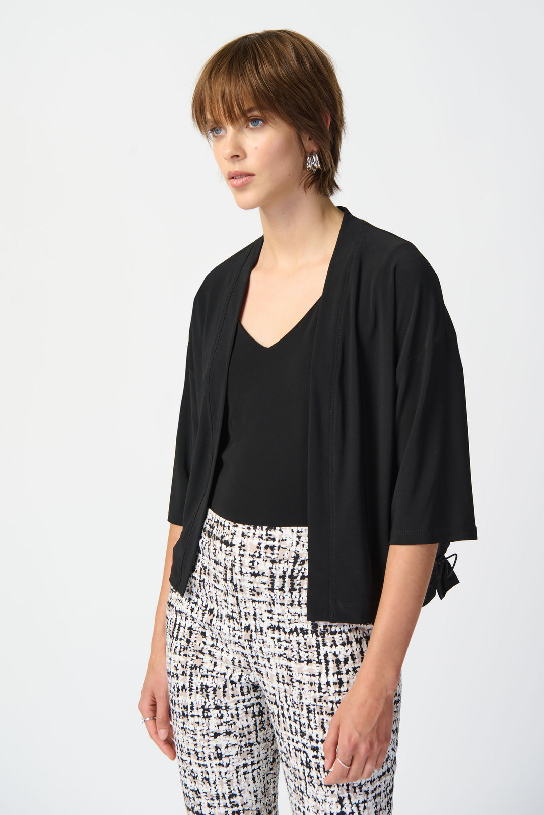 This cropped open cardigan doubles as a top and features a sleek, contrasting memory fabric back for a modern twist. Its light and relaxed fit adds an effortless touch to any outfit.