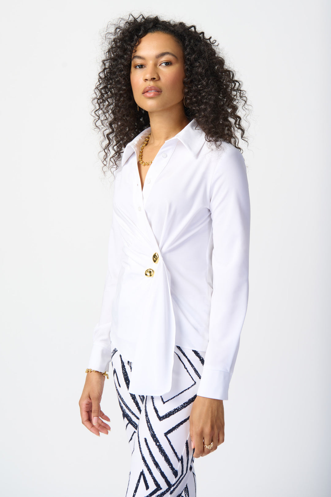Joseph Ribkoff Fall 2024  The wrap front design, along with the two gold button front closure, exudes sophistication. Made from stretch woven fabric, it flatters the figure with its asymmetrical cut front hem. 