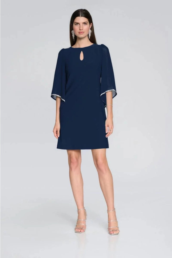 Joseph Ribkoff Summer 2024 Crafted by renowned designer Joseph Ribkoff and made in Canada, the dress features a keyhole neckline, 3/4 length chiffon sleeves with&nbsp;rhinestone border for a glamorous touch.