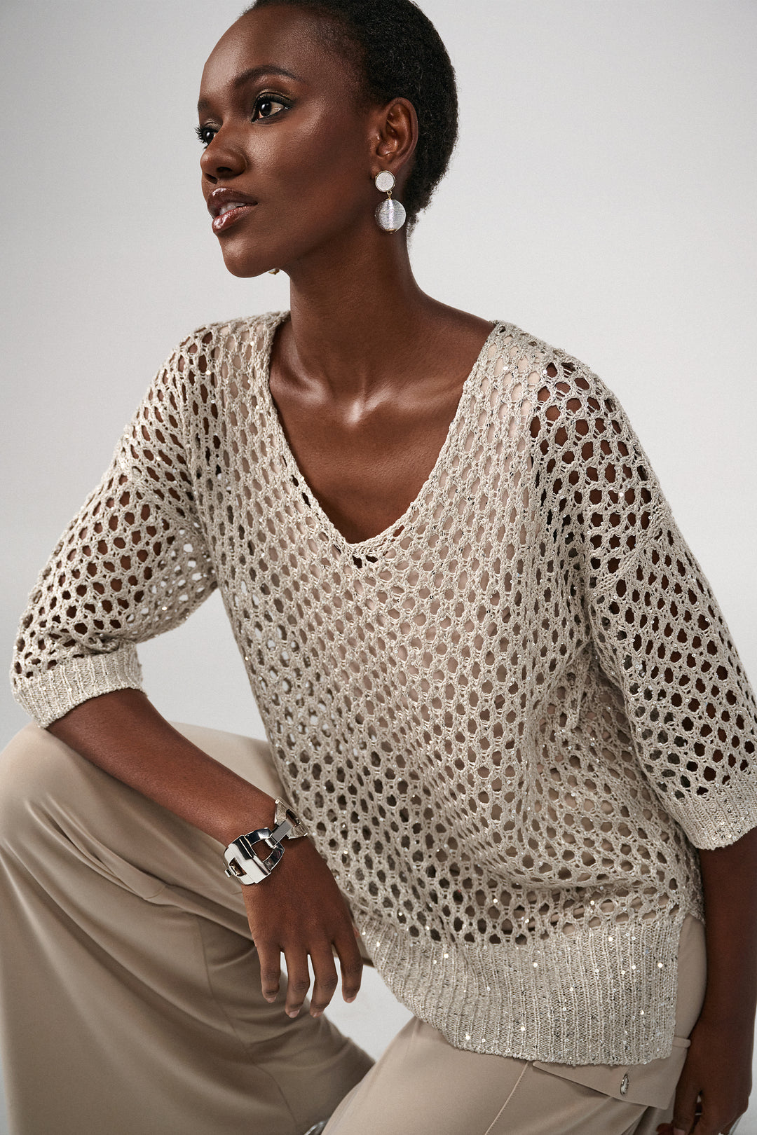 Indulge in luxury with our crochet top featuring intricate sequin detailing.