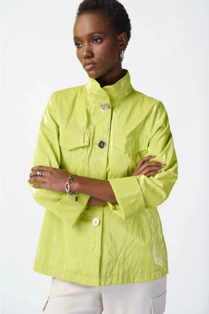 Joseph Ribkoff Summer 2024 featuring a sleek funnel collar, luxurious sheen finish and slight crinkle texture. Perfect for light rain, this practical jacket boasts front pockets, neat cuffed sleeves and a front button closure.