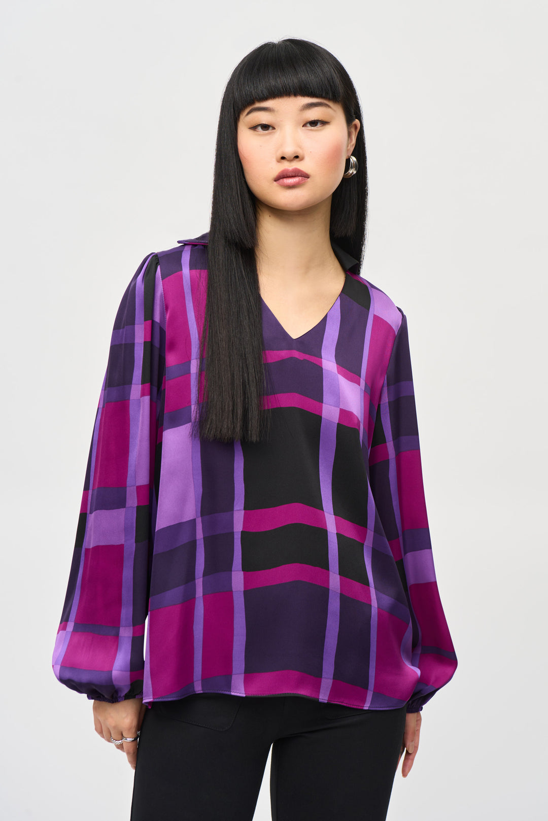 Joseph Ribkoff Fall 2024 Crafted from luxurious satin fabric, this V-neck top boasts a colourful plaid design for a statement-making look. Boxy in style and fit, it features long loose sleeves with elastic cuffs and a sharp V-neckline. 