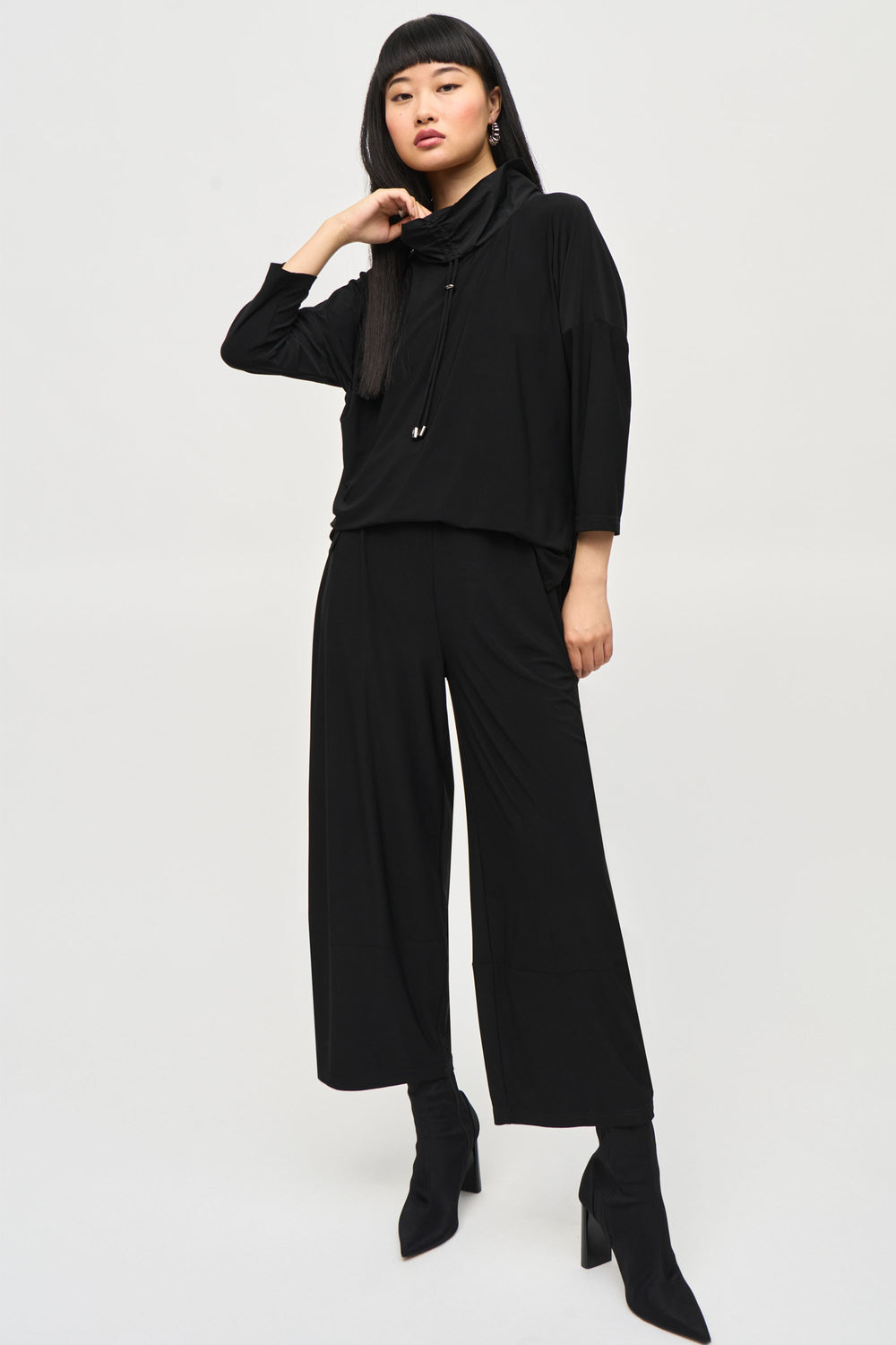 Joseph Ribkoff Fall 2024 Stay stylish and comfortable with our Cowl Neck Jumpsuite Featuring 3/4 length sleeves and a wide leg pant, this all-in-one piece is simple yet chic.