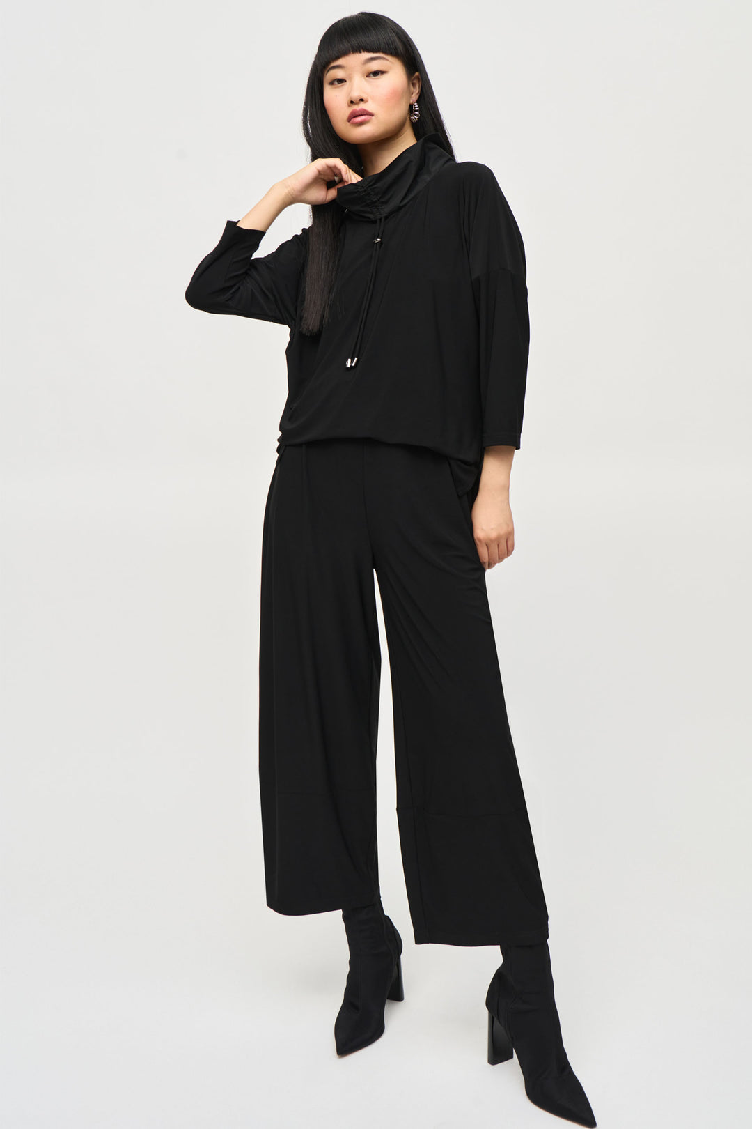 Joseph Ribkoff Fall 2024 Stay stylish and comfortable with our Cowl Neck Jumpsuite Featuring 3/4 length sleeves and a wide leg pant, this all-in-one piece is simple yet chic.
