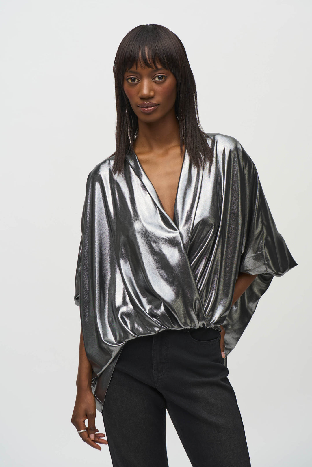 Joseph Ribkoff Fall 2024  The metallic shine exudes luxury while the chiffon fabric gives a light and airy feel. With cuffed dolman sleeves and a wrap design, this top is a statement piece perfect for any special occasion. 