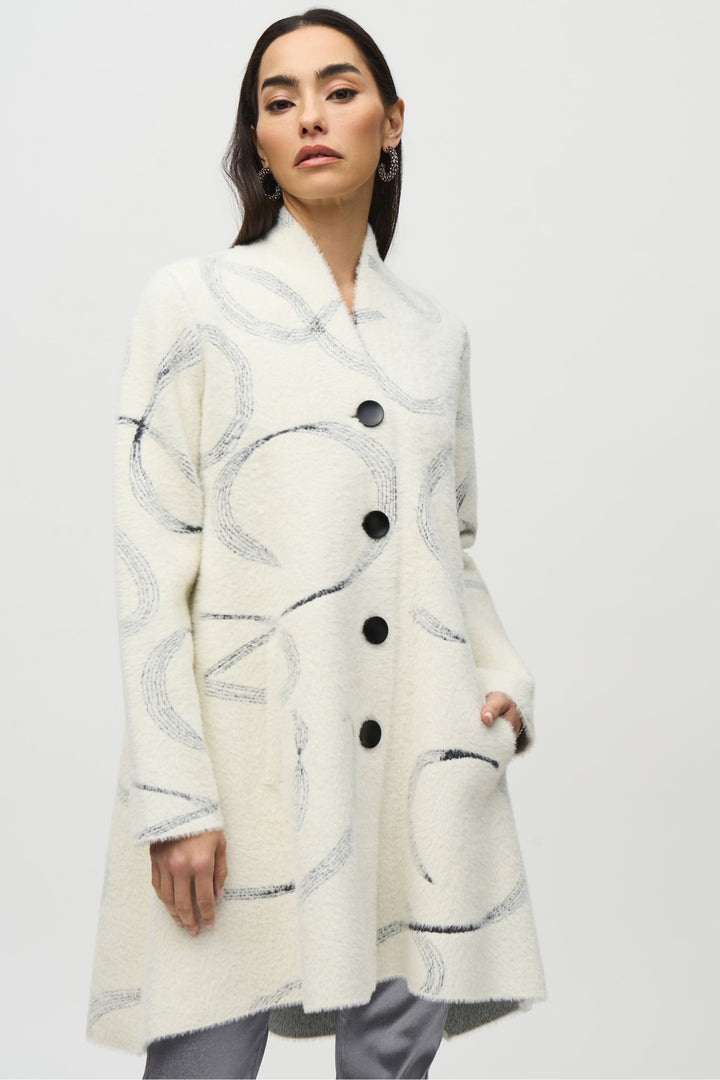 Joseph Ribkoff Fall 2024  The star of the show is the mesmerizing swirl print design, accentuated by the neat shawl collar. Its to-the-knee length adds sophistication to any outfit. 