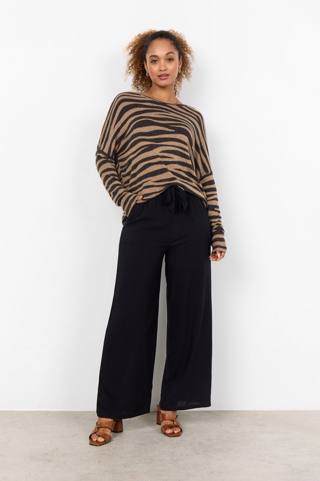 Soya Concept Fall 2024 This Animal Print Dolman Top is the perfect way to bring a little adventure to your basics! It has a round neckline and long sleeves and is a comfortable and slightly loose fit. 