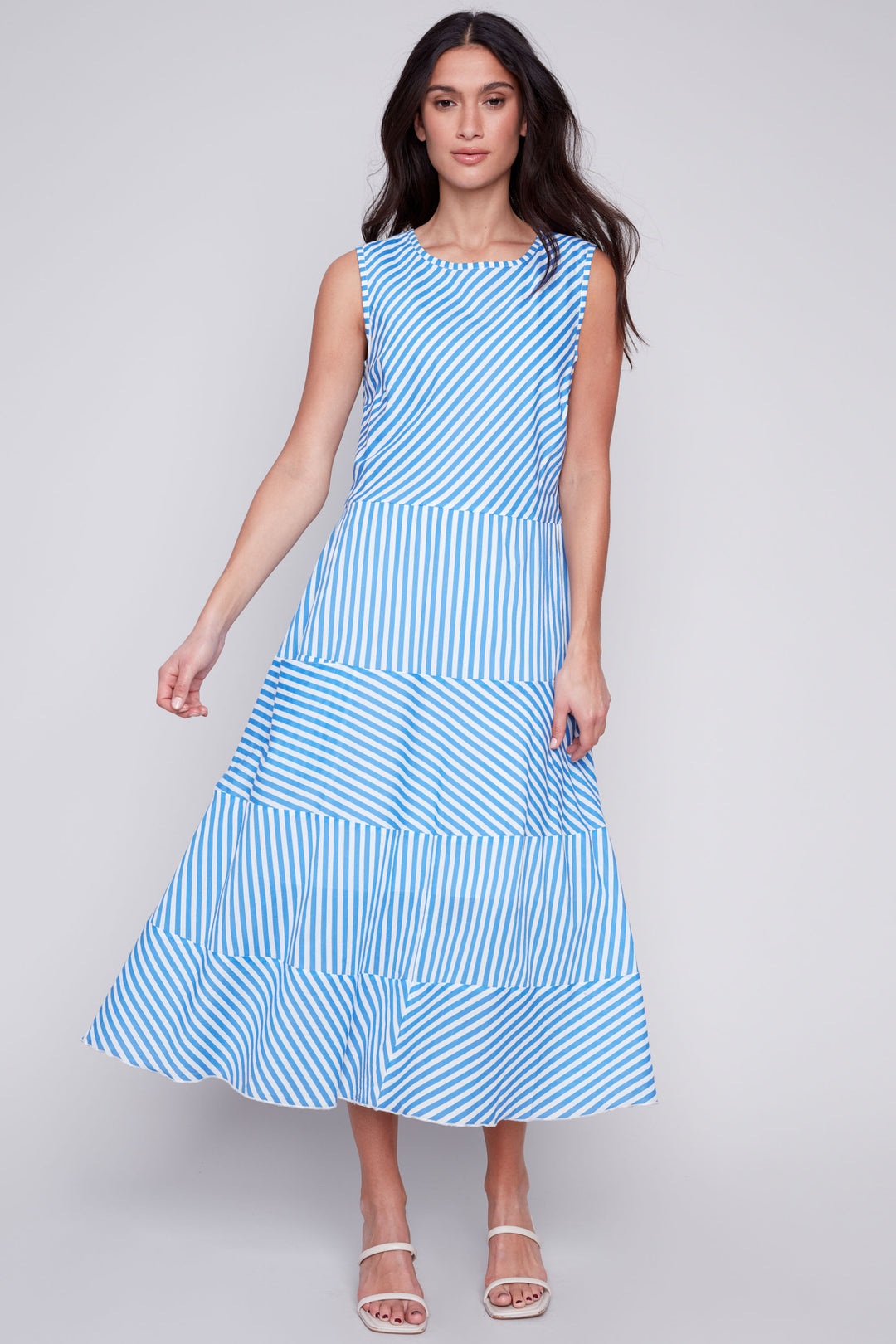 Charlie B Spring 2024 Made of all cotton, this dress boasts a classic skirt hem and convenient pockets. The sleeveless design and captivating stripe pattern make this free-flowing dress a must!