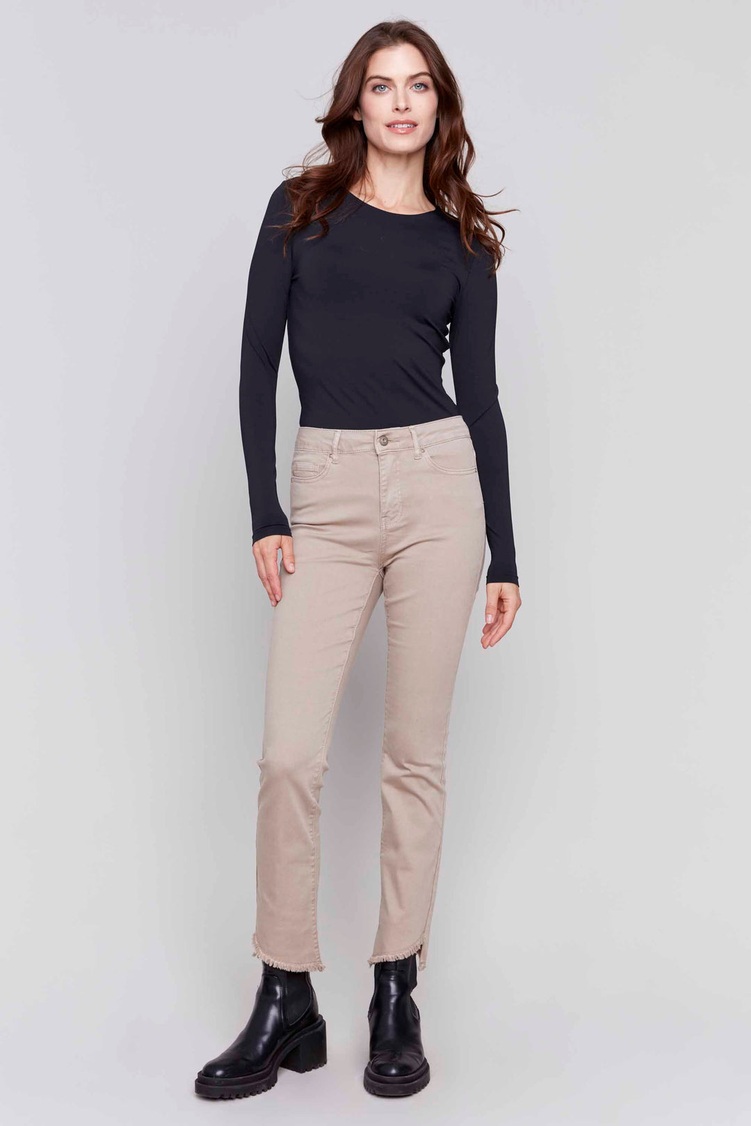 Charlie B Fall 2024 Featuring a flattering mid rise, slim fit and nice bootcut, our cotton twill pant is both comfortable and chic. The fringe detail on the asymmetrical leg opening adds a unique touch to your look.