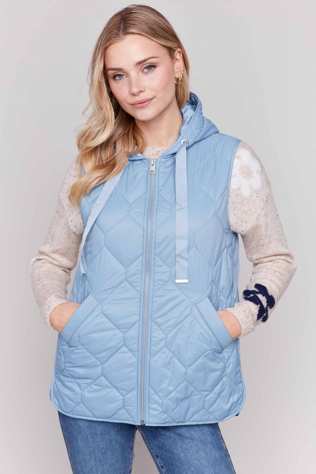 Charlie B Fall 2024 Complete with a hood and drawstring, as well as a front zipper and pockets, this vest is a must-have for any fashion-forward individual! Stay warm and stylish with our&nbsp; Quilted Hoodie Vest!