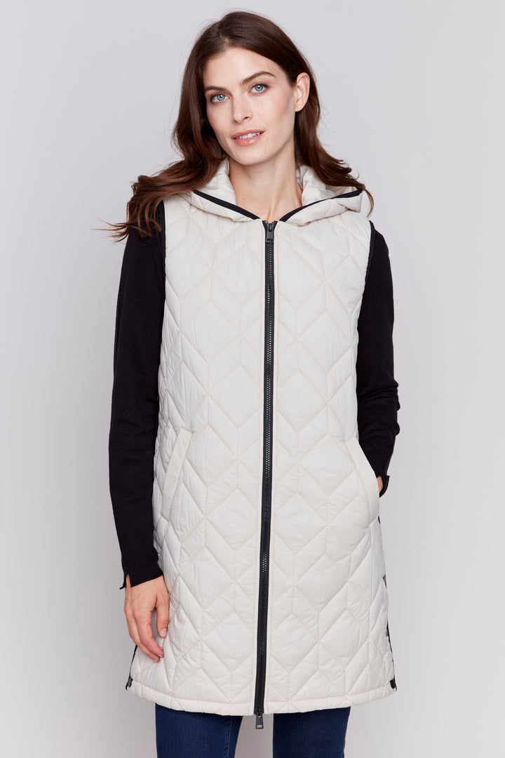 Charlie B Fall 2024 Perfect for keeping warm without compromising your style, this vest features a quilted pattern in either red or white (almond), long design with a hood and pockets that you'll love sporting all season long!