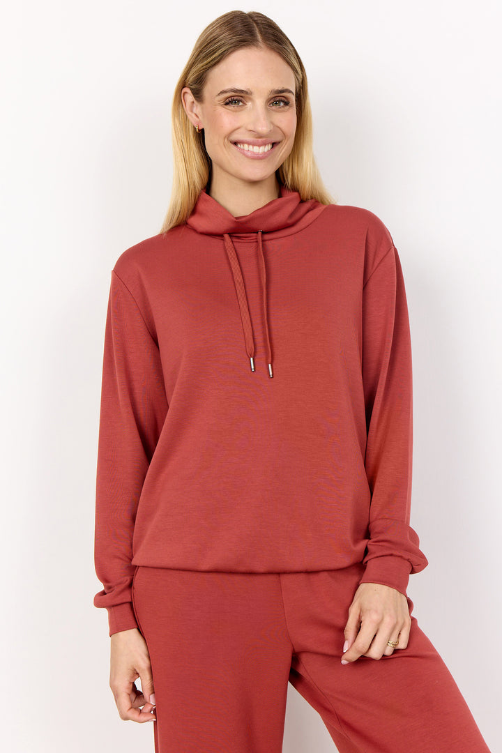 Soya Concept Fall 2025 
Featuring a bold and simple design, the high neckline and drawstring add both functionality and fashion to this top.