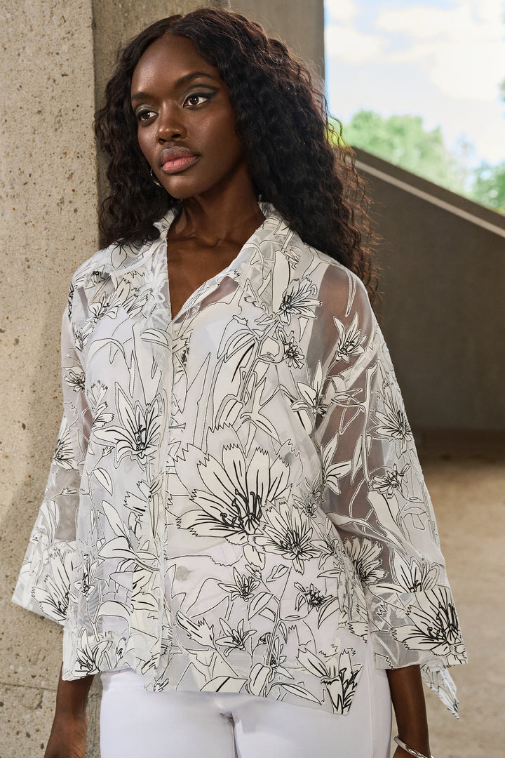 Joseph Ribkoff Spring 2025 Its boxy cut fit effortlessly layers over any top, and its black and white floral print exudes elegance. With side cut slits, this exclusive piece adds a touch of sophistication to any ensemble this spring and summer